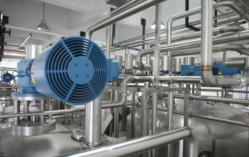 Stainless steel process piping with a blue electric motor