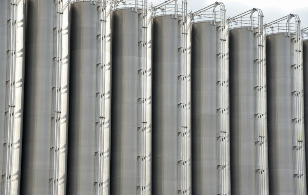 Row of tall stainless steel storage silos