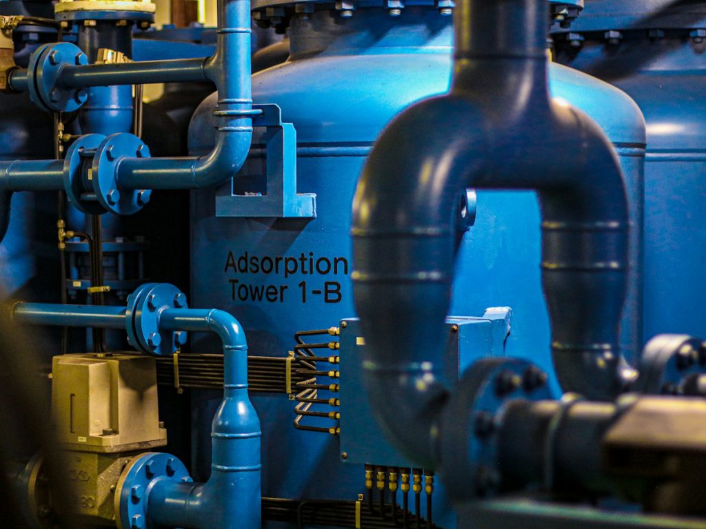 Blue adsorption vessel with flanged piping and valves