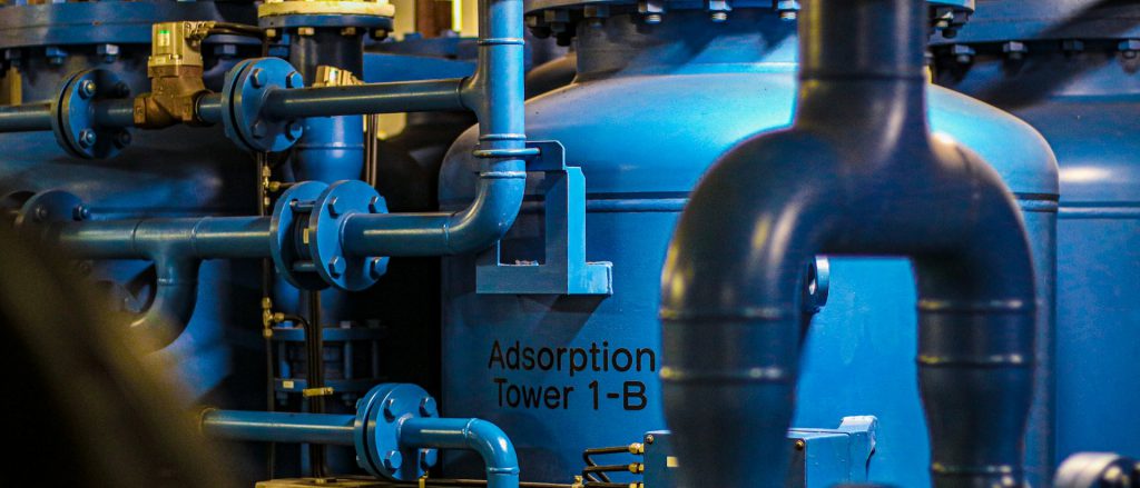 Blue adsorption vessel with flanged piping and valves