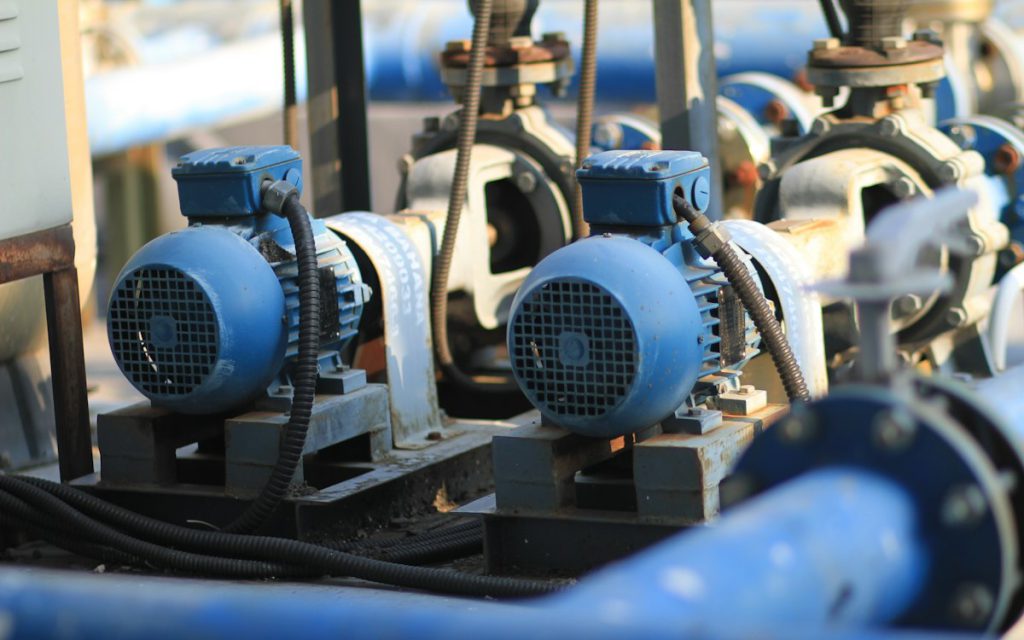 Row of electric motor-driven centrifugal pumps with blue piping