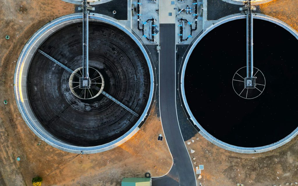 Aerial view of two circular clarifier tanks at a water treatment plant