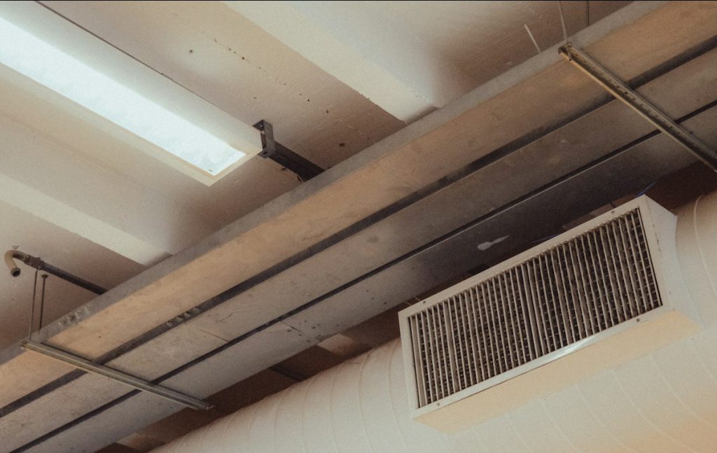 Supply air grille on a duct along an industrial ceiling