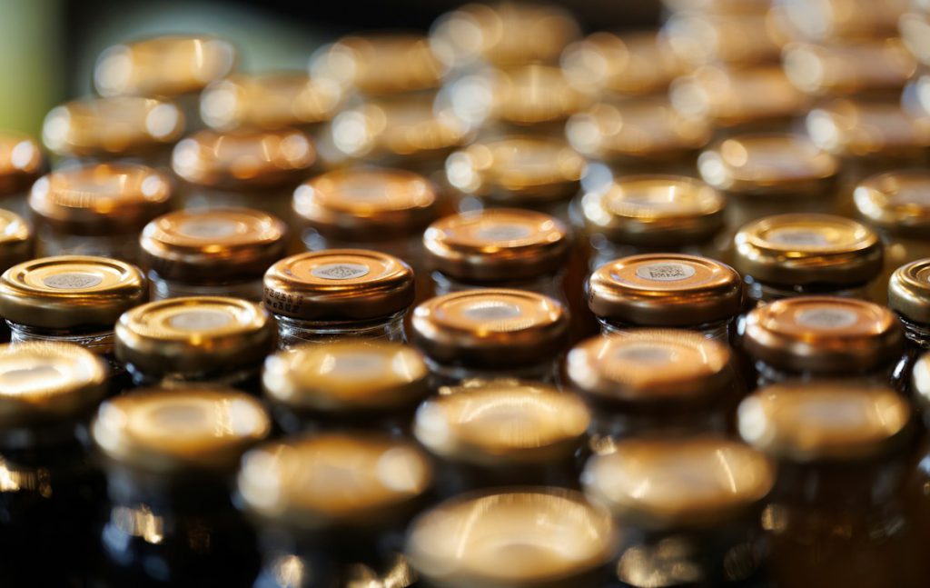 Rows of capped glass bottles on a beverage bottling line